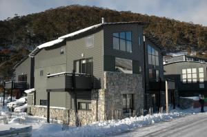 a large house in the snow in front of a mountain at Blues Air 3 in Thredbo