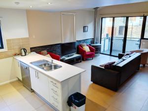 a kitchen and living room with a couch and a sink at Blues Air 3 in Thredbo
