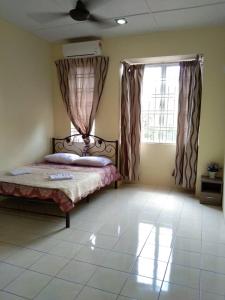 een slaapkamer met een bed en een raam bij KERAI GUEST HOUSE TEMERLOH in Kampong Telok Mengkuang