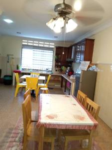 a kitchen with a table and chairs and a dining room at KERAI GUEST HOUSE TEMERLOH in Kampong Telok Mengkuang