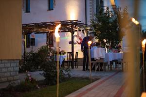 Un uomo in piedi davanti a un tavolo in un ristorante di Pensiunea Diana a Stroe Beloescu