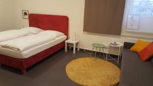 - une petite chambre avec un lit et un canapé dans l'établissement City Center Apartments Linz, à Linz
