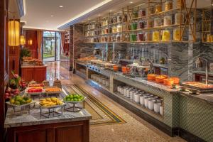 a buffet line in a restaurant with fruits and vegetables at Silk Path Grand Hue Hotel in Hue