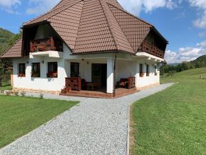 VidraにあるPensiunea Casa Ianculuiの茶色の屋根の小さな白い家