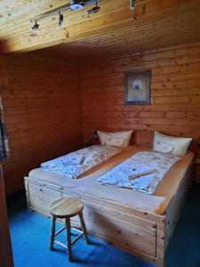 une chambre avec deux lits dans une cabane en rondins dans l'établissement Ferienwohnung Haus Waldeck, à Neuhermsdorf