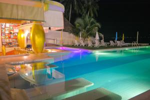 a swimming pool at a resort at night at Le Divine Comedie Beach Resort in Baan Tai