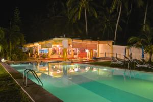 una piscina con sillas y una casa por la noche en Le Divine Comedie Beach Resort, en Baan Tai