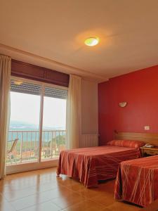 a hotel room with two beds and a large window at Hostal Las Vegas in Cangas de Morrazo +14 photos