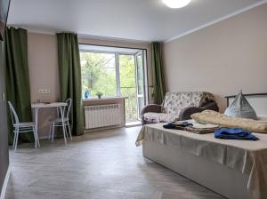 オムスクにあるАпартаменты на Набережной Иртыша Бесплатно встречаのベッド1台、ソファ、窓が備わる客室です。