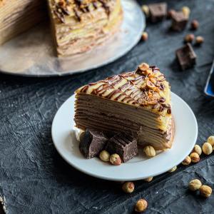 um pedaço de bolo de chocolate num prato numa mesa em Lazenda Hotel em Labuan