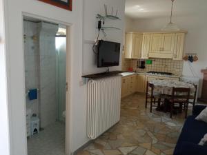 a kitchen with a refrigerator and a table and a television at GIARDINO SUL MARE in Amalfi