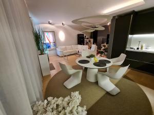 a living room with a table and white chairs at Kreutzwaldi Penthouse in Tallinn