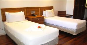 A bed or beds in a room at Madang Star International Hotel