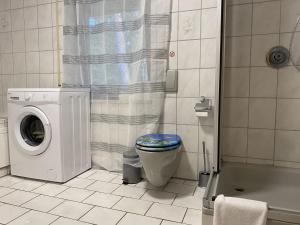a bathroom with a toilet and a washing machine at WA120 - Monteurwohnung in Wackersdorf in Wackersdorf