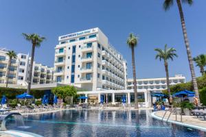 a hotel with a swimming pool and palm trees at Anonymous Beach Hotel (Adults 16+) in Ayia Napa