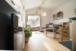 a living room with a table and a dining room at Bio-Ferienhaus Newergarten in Wadern