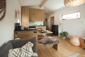 ein Wohnzimmer mit einem Sofa und einer Küche in der Unterkunft Bio-Ferienhaus Newergarten in Wadern