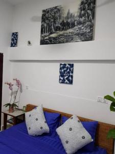 a bed with a blue and white comforter and pillows at RS Guesthouse in Phnom Penh
