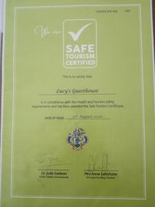 uma caixa verde com um certificado com um anel em Lucy's guesthouse em La Digue