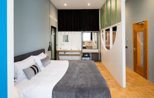 a bedroom with a large bed and a kitchen at Quentin Zoo hotel in Amsterdam