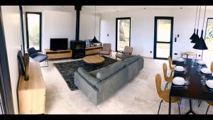 a living room with a couch and a table at Villa Fogata à l'Ile Rousse vue mer exceptionnelle in LʼÎle-Rousse