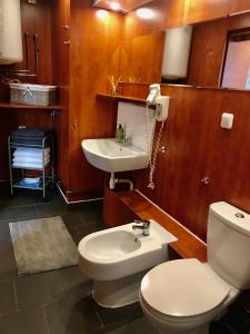 a bathroom with a toilet and a sink at Lägenhet med 3 sovrum, terass och egen parkering in Oxie