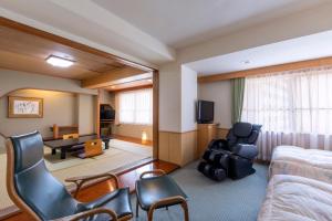 a hotel room with a bed and a living room at Noboribetsu Sekisui Tei in Noboribetsu