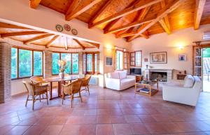 a living room with wooden ceilings and a table and chairs at Doliva Estate in Laganas