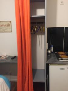 petit studio fonctionnel independant في سانت بريوك: ستارة برتقالية في مطبخ مع مكتب