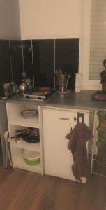 petit studio fonctionnel independant في سانت بريوك: مطبخ مع دولاب عليه مظله