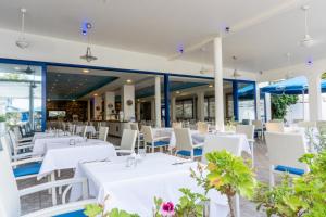 a restaurant with white tables and white chairs at Anonymous Beach Hotel (Adults 16+) in Ayia Napa