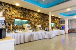 a restaurant with a stone wall and a counter at Anonymous Beach Hotel (Adults 16+) in Ayia Napa