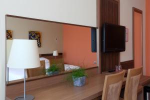 a living room with a mirror and a tv at Hotel Kras in Postojna
