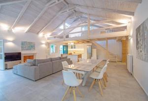 a dining room and living room with a table and chairs at Doliva Estate in Laganas