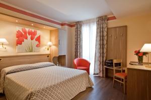 Cette chambre comprend un lit et un bureau. dans l'établissement Hotel Astra, à Tignale