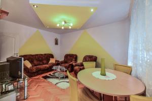 un soggiorno con tavolo e divano di Lux Apartman Cvetkovic a Kraljevo
