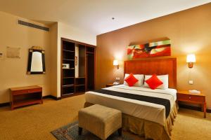 a hotel room with a large bed with red pillows at مينا بلازا الطائف Mena Plaza Taif in Taif