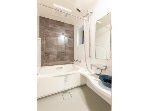 a white bathroom with a sink and a mirror at SYA Hotel-祇園 in Fukuoka