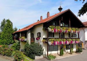 a building with lots of flowers on it at Wohlfühl-Ferienwohnungen Kirchberger in Bodenmais