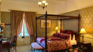 1 dormitorio con cama con dosel y escritorio en Bli Bli House Riverside Retreat, en Twin Waters