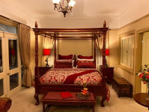 a bedroom with a canopy bed with red pillows at Bli Bli House Riverside Retreat in Twin Waters