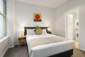 a bedroom with a bed and a table and a window at Quest on William in Melbourne +33 photos