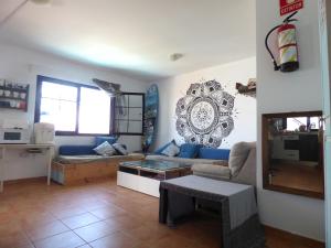 a living room with a blue couch and a mirror at La Fresa Hostel in Corralejo