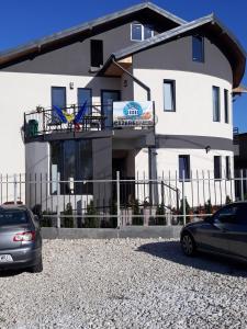 a white building with cars parked in front of it at ROMSIL CASA VACANTA in Costinesti