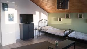 a room with two beds and a flat screen tv at Word & stay Vohburg near Ingolstadt in Vohburg an der Donau