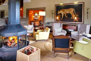 a living room filled with furniture and a fire place at Pumba Private Game Reserve in Yarrow