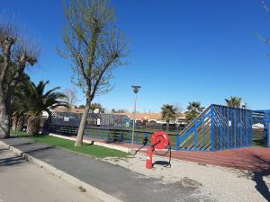 a red fire hydrant in front of a playground at LA CARABASSE CP90 in Vias