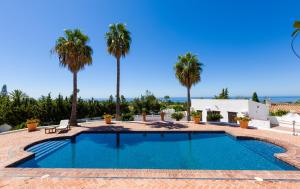 a swimming pool in a resort with palm trees at Cortijo Boutique Marbella in Marbella