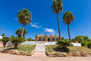 a house with palm trees in front of it at Cortijo Boutique Marbella in Marbella