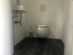 a bathroom with a toilet in a white room at Op de linge in Rumpt